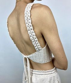 the back of a woman's bra with crochet on it and her hands in her pockets