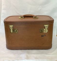 "CLASSIC MID-CENTURY TRAVEL ESSENTIAL SKYWAY overnight bag/train case/carry-on suitcase. A vintage stitch-bound trim solid piece of luggage. It has heavy-duty working spring action locking brass latches with the original Skyway Luggage key pinned inside (just like Mom always told us to do).  The suitcase has four solid brass stud feet. The leather (?) handle is firmly secured in place and is ready to carry your personal possessions.  The Skyway train case can also be repurposed as a home decor item or a unique stash box.  This hardshell Skyway Luggage is in very good pre-owned vintage condition.  The outside has the expected dings, marks, and scratches for its age, and are indicated in the photos.  The inside is clean and free of any stains, or tears. Overall very sturdy. The carry-on suit Brown Rectangular Cases For Trip, Rectangular Brown Cases For Trip, Brown Rectangular Cases For Trips, Retro Rectangular Travel Case Bag, Retro Rectangular Cases With Luggage Sleeve, Vintage Brown Leather Case, Classic Rectangular Cases For Overnight Trips, Vintage Brown Leather Cases, Vintage Brown Rectangular Case Bag