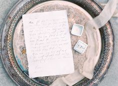 a piece of paper sitting on top of a metal tray next to a cell phone