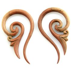 two wooden earrings with swirl designs on the sides and one has an ear hole in the middle