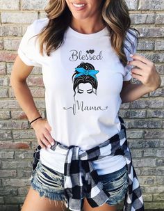 Blessed Mama Messy Bun Short Sleeve Tee This classic unisex jersey short sleeve tee fits like a well-loved favorite. Soft cotton and quality print make users fall in love with it over and over again. These t-shirts have-ribbed knit collars to bolster shaping. The shoulders have taping for better fit over time. Dual side seams hold the garment's shape for longer.  .: 100% Airlume combed and ringspun cotton (fiber content may vary for different colors) .: Light fabric (4.2 oz/yd² (142 g/m .: Retai Cotton T-shirt With Sublimation Print For Mother's Day, Mother's Day Cotton T-shirt With Sublimation Print, Casual Sublimation Print Top For Mother's Day, Mother's Day Casual Tops With Sublimation Print, Short Sleeve Tops With Sublimation Print In Ring-spun Cotton, Short Sleeve Ring-spun Cotton Top With Sublimation Print, Casual Sublimation Print T-shirt For Mother's Day, Casual T-shirt With Sublimation Print For Mother's Day, Blessed Mama Shirt