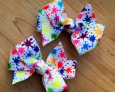 four different colored bows on top of a wooden table