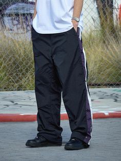 These street mood track pants are designed with color-blocking strips and snap buttons at side panel to adjust fit and add color accent. It's cut from durable nylon that's light, breathable, and also has windproof and water-resistant function.- Elasticated waistband with inside drawstring- Two front slash pockets- Logo embroidery at front- Color-blocking side panel with snap button closure- Adjustable drawcord and stopper at hem - Mesh lining- Relaxed fit- Unisex wear Streetwear Bottoms With Contrast Color And Long Pants, Sporty Pants With Contrast Color For Sports, Streetwear Bottoms With Contrast Stripes, Sporty Contrast Color Pants For Streetwear, Sporty Streetwear Pants With Contrast Color, Sporty Contrast Color Pants, Sporty Sweatpants With Contrast Color For Streetwear, Athleisure Streetwear Pants With Contrast Stripes, Athleisure Pants With Contrast Stripes For Streetwear