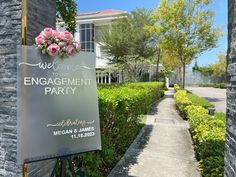 a welcome sign for an engagement party in front of a building with flowers on it