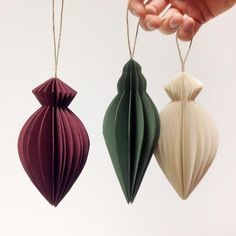 two origami ornaments being held by someone's hand