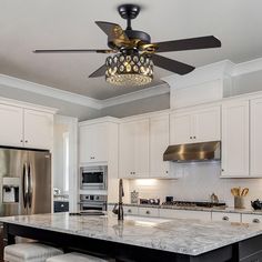 a kitchen with white cabinets and marble counter tops, an island with stools and a chandelier