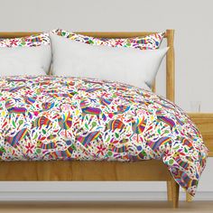 a bed with white pillows and colorful comforter