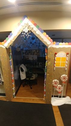 an indoor christmas scene made out of cardboard and decorated with candy canes, lollipops, marshmallows, and snowflakes