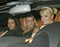 three women sitting in the back seat of a car