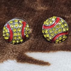 two yellow and red earrings sitting on top of a brown carpet