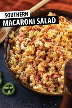 a bowl filled with macaroni salad next to green peppers