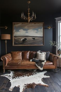 a living room with leather furniture and cow hide rugs on the hardwood flooring