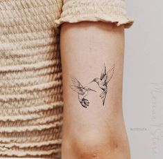 a small hummingbird tattoo on the right arm