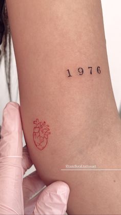 a woman's arm with a small heart tattoo on the left side of her leg