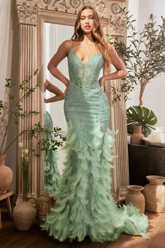 Stun in this feather mermaid gown! This gorgeous dress features a mermaid silhouette for an ultra-glamorous, figure-flattering look. The glitter lattice motif adds just the right amount of sparkle and shine to draw attention to your curves. The top boasts thin straps and a plunging neckline, along with a sheer bodice complete with boning for a secure and flattering fit. The pièce de résistance of this gown is the faux feathered godets which will have you feeling like a goddess. The lace up corset back finish off the look and will have everyone’s eyes on you when you enter the room. Prom Mermaid, Cinderella Divine, Trumpet Skirt, Designer Prom Dresses, Sleeveless Long Dress, Stunning Gowns, Mermaid Skirt, Mermaid Silhouette, Mermaid Gown