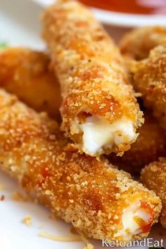 some fried food on a white plate with ketchup and mustard in the background