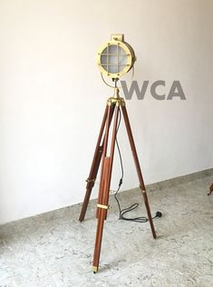 a tripod light sitting on top of a wooden stand in front of a wall