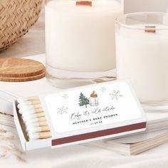 a box of matches sitting on top of a table next to a candle