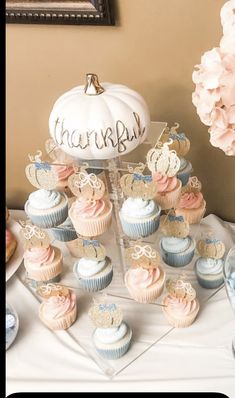 a table topped with lots of cupcakes covered in frosting