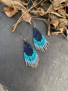 Navy blue turquoise ombre earrings - Small Beaded earrings - Fringe dangle earrings - Short beaded earrings - Bohemian earrings- Boho chic ♥𝑇ℎ𝑒 𝑝𝑎𝑡𝑡𝑒𝑟𝑛 𝑜𝑓 𝑡ℎ𝑖𝑠 𝑒𝑎𝑟𝑟𝑖𝑛𝑔 𝑖𝑠 𝑐𝑟𝑒𝑎𝑡𝑒𝑑 𝑏𝑦 𝐾𝑎𝑍𝑒𝐵𝑒𝑎𝑑𝐽𝑒𝑤𝑒𝑙𝑟𝑦 ♥𝑀𝑎𝑑𝑒 𝑢𝑠𝑖𝑛𝑔 𝑓𝑟𝑒𝑒ℎ𝑎𝑛𝑑 𝑏𝑒𝑎𝑑𝑖𝑛𝑔 𝑤𝑜𝑣𝑒𝑛 𝑡𝑒𝑐ℎ𝑛𝑖𝑞𝑢𝑒𝑠 𝑤𝑖𝑡ℎ 𝑠𝑡𝑟𝑜𝑛𝑔 𝑠𝑦𝑛𝑡ℎ𝑒𝑡𝑖𝑐 𝑡ℎ𝑟𝑒𝑎𝑑. ♥𝑇ℎ𝑒 𝑠𝑖𝑧𝑒 𝑜𝑓 𝑡ℎ𝑒 𝑠𝑒𝑒𝑑 𝑏𝑒𝑎𝑑𝑠 𝑢𝑠𝑒𝑑 𝑖𝑠 2 𝑚𝑖𝑙𝑙𝑖𝑚𝑒𝑡𝑒𝑟𝑠 𝑎𝑛𝑑 𝑏𝑒𝑎𝑑𝑠 𝑎𝑟𝑒 ℎ𝑖𝑔ℎ 𝑞𝑢𝑎𝑙𝑖𝑓𝑖𝑒𝑑. ♥𝐴𝑙𝑙 𝑡ℎ𝑒 ℎ𝑜𝑜𝑘𝑠 𝑢𝑠𝑒𝑑 𝑖𝑛 𝑜𝑢𝑟 𝑗𝑒𝑤𝑒𝑙𝑟𝑦 𝑎𝑟𝑒 24 𝑘 𝑔𝑜𝑙𝑑 𝑝𝑙𝑎𝑡𝑒𝑑 𝑎𝑛𝑑 ℎ𝑦𝑝𝑜𝑎𝑙𝑙𝑒𝑟𝑔𝑒𝑛𝑖𝑐. ♥𝑇ℎ𝑒𝑠𝑒 𝑎𝑟𝑒 𝑣𝑒𝑟𝑦 𝑙𝑖𝑔ℎ𝑡 𝑒𝑎𝑟𝑟𝑖𝑛𝑔𝑠 𝑡ℎ𝑎𝑡 𝑦𝑜𝑢 𝑐𝑎𝑛 𝑤𝑒𝑎𝑟 𝑎𝑙𝑙 𝑑𝑎𝑦 𝑤𝑖𝑡ℎ𝑜𝑢𝑡 ℎ𝑢𝑟𝑡𝑖𝑛𝑔 𝑦𝑜𝑢𝑟 𝑒𝑎𝑟! The onl Cheap Blue Bohemian Beaded Earrings, Cheap Bohemian Blue Beaded Earrings, Short Fringe Beaded Earrings, Small Beaded Earrings Native American, Blue Beaded Fringe Earrings, Short Beaded Earrings, Small Beaded Earrings, Earring Inspired, Turquoise Ombre