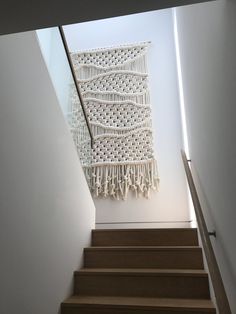 there is a white crocheted wall hanging above the stairs