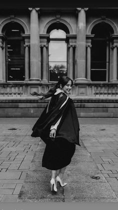 a woman is walking down the street in front of an old building