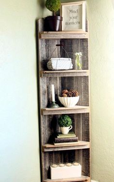 a wooden shelf with some plants and other items on it in the corner of a room