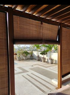 an outdoor area with potted plants and wooden slats on the roof, as seen from outside