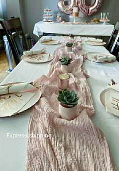 a long table with plates and succulents is set up for a party