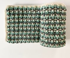 a crocheted dishcloth is shown on a white surface with green and brown accents