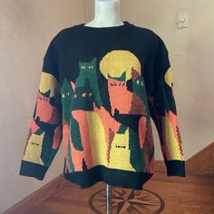 This Is A New, Black, Long-Sleeved Sweater With A Crew Neck. It Features A Colorful Cat Design In Shades Of Green, Yellow, And Orange. The Sweater Is Made Of A Soft, Knitted Fabric And Has A Relaxed Fit. It Is Approximately 24 Inches Long And Has A 20-Inch Sleeve Length. The Sweater Is Tagged With A Size L, But Measures Better Fitted To A Medium And The Brand "K-Cult." It Is In New Condition With Tags Purrrrrfect Motif For Getting You In The Halloween Spirit Bin 334 Cat Colors, Crew Neck Sweater, Orange Black, Sweater Sizes, New Black, Long Sleeve Sweater, Sweater Top, Sweaters For Women, Sleeve Length