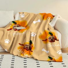 a blanket with a dog's name and paw prints on it sitting on a couch