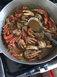 crab legs and other seafood are being cooked in a pan on the stove