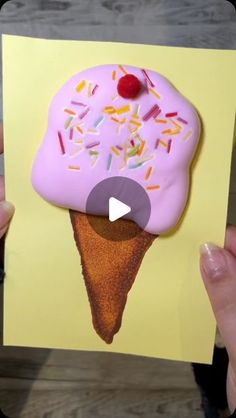 an ice cream cone with sprinkles on it is being held up by someone