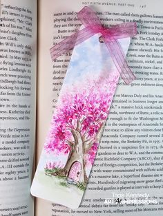 an open book with a pink tree on it