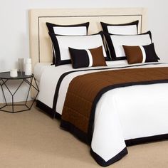 a bed with black and white pillows on it