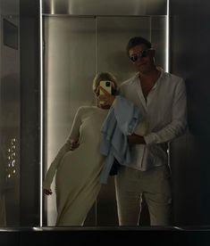 a man and woman taking a selfie in an elevator