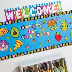 a welcome sign hanging on the wall above a children's book shelf filled with books