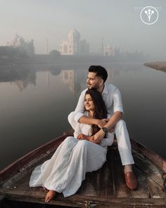 a man and woman sitting on the back of a boat in front of a body of water