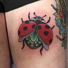 a lady bug tattoo on the thigh