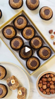 nuts and chocolates are on the table next to a tray with cupcakes