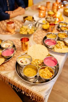 a table filled with lots of food on top of a white tablecloth covered table