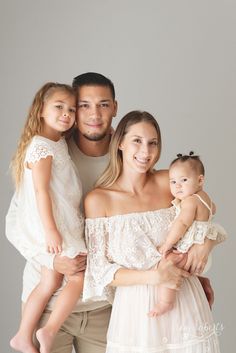 a man, woman and two children posing for a photo with their arms around each other