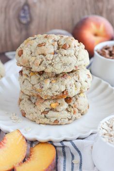 three oatmeal cookies stacked on top of each other with peaches in the background