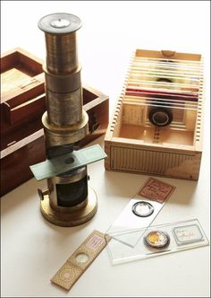 an old fashioned camera sitting on top of a table next to some stamps and other items