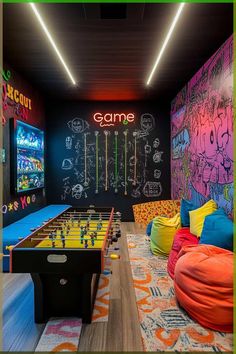 an indoor game room with bean bag chairs and neon lights on the ceiling, chalkboard walls