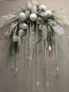 a christmas wreath with ornaments hanging from it's sides and snowflakes on the top