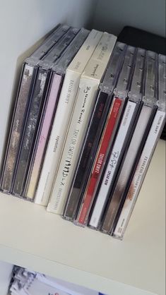 there are many cd's on the shelf together