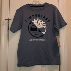 Brand New Timberland Boys T-Shirt! In The Color Blue And In The Size 8! Outdoor Blue Cotton Tops, Blue Cotton Tops For Outdoor, Blue Cotton Outdoor T-shirt, Outdoor Blue Cotton T-shirt, Blue Graphic Print Top For Outdoor, Blue Short Sleeve T-shirt For Outdoor, Outdoor Cotton Tops With Logo Print, Outdoor Blue T-shirt With Letter Print, Blue T-shirt With Letter Print For Outdoor