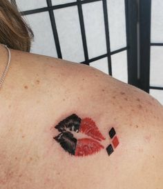 a woman's shoulder with a red and black lipstick imprint on her left side